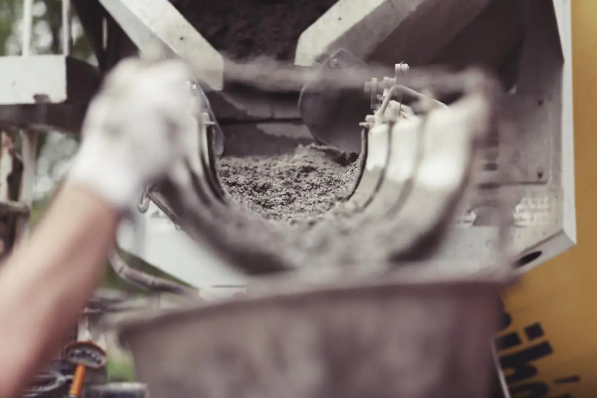 Mains gantées travaillant le mortier sur un chantier