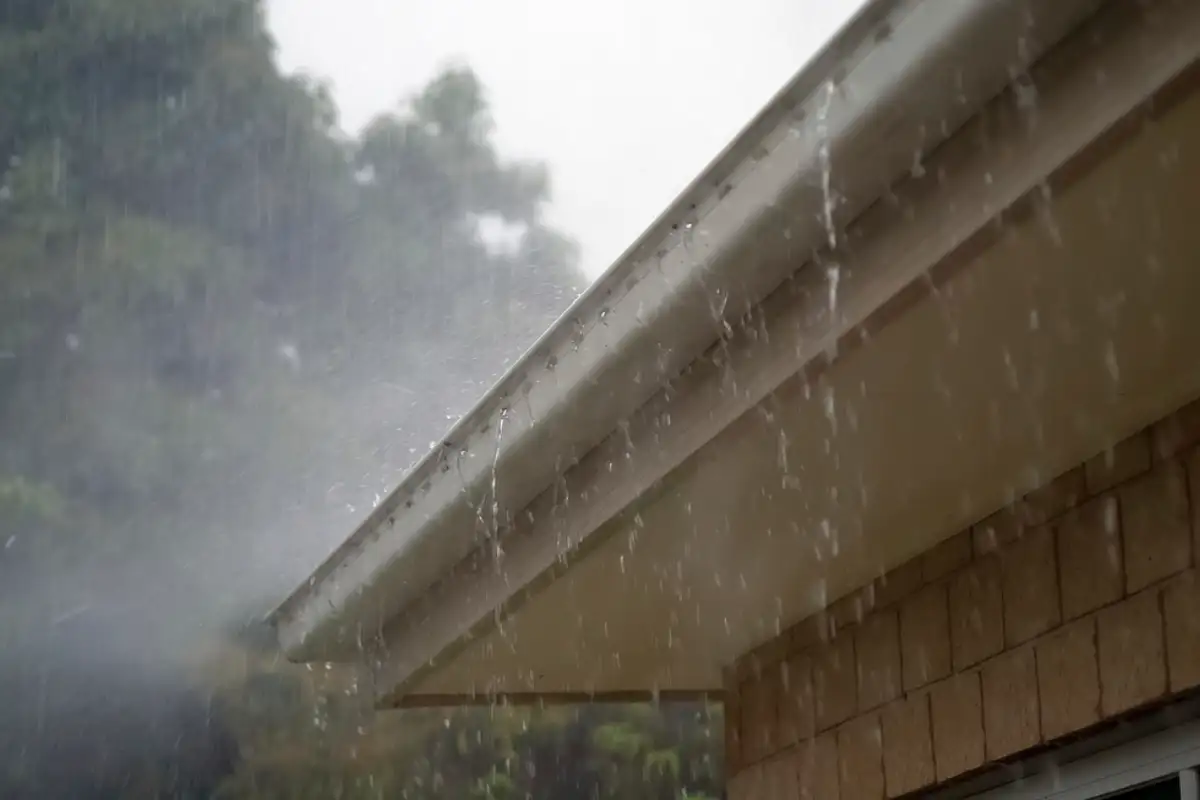 Gouttière en zinc recevant l'eau de pluie le long d'un débord de toiture