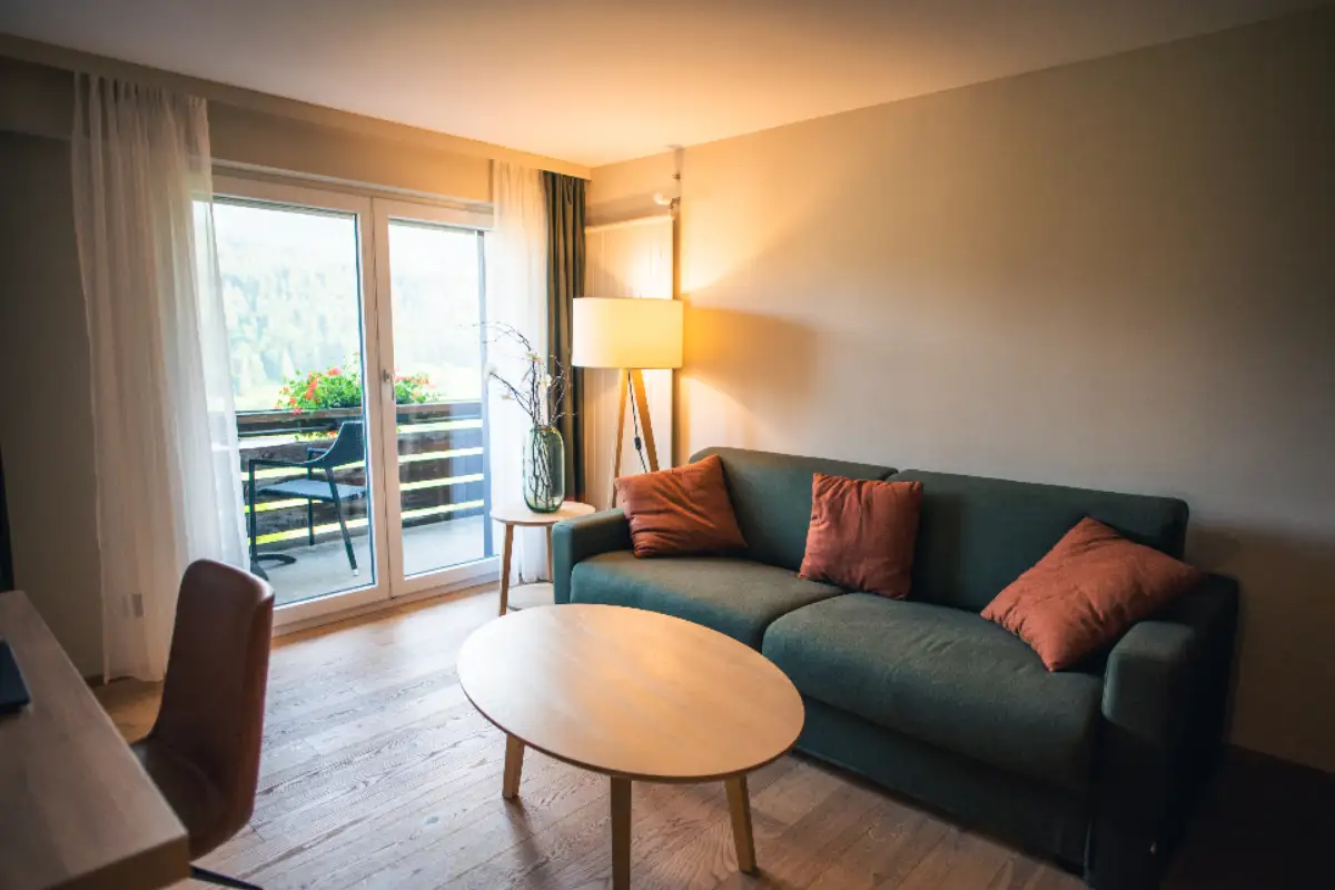 Salon d'une chambre d'hôtel ouvrant sur un balcon