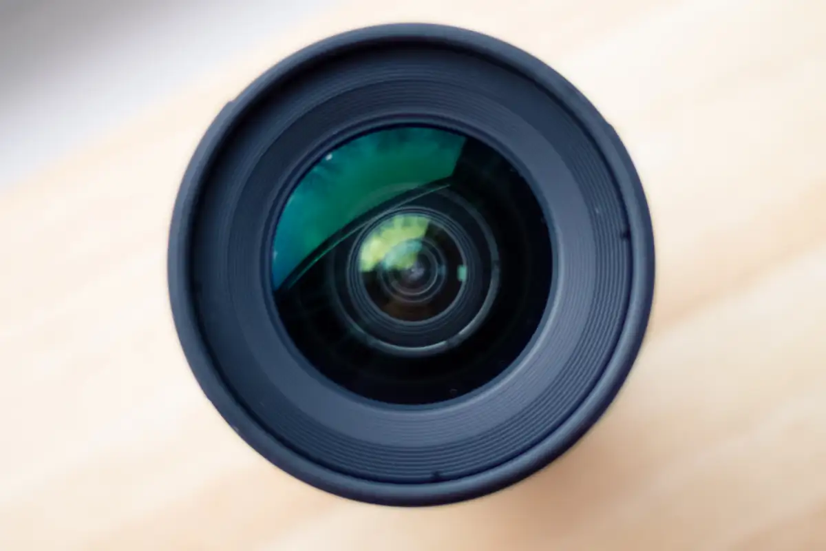 Objectif photographique posé sur un plan de travail clair