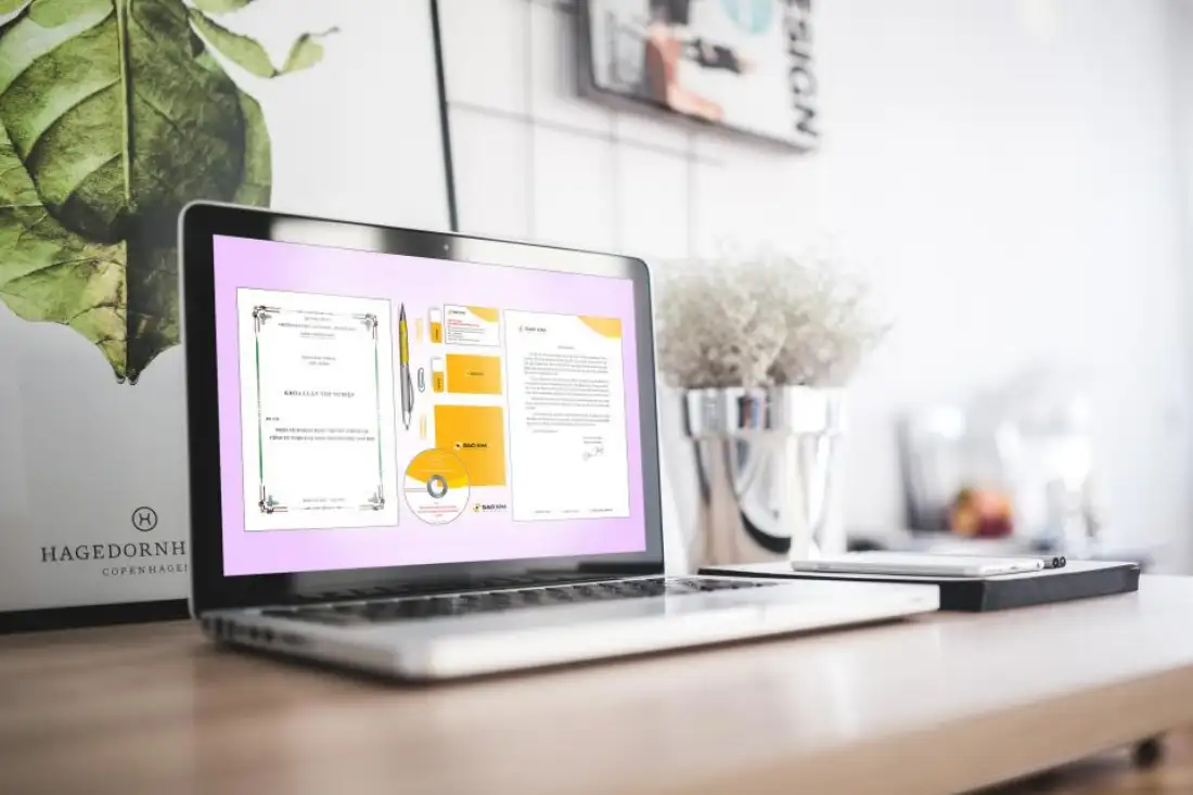 Plan de travail : ordinateur portable affichant une maquette de site, carnet et plante