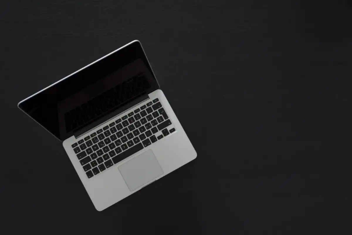 Ordinateur portable ouvert, vu de dessus sur fond sombre